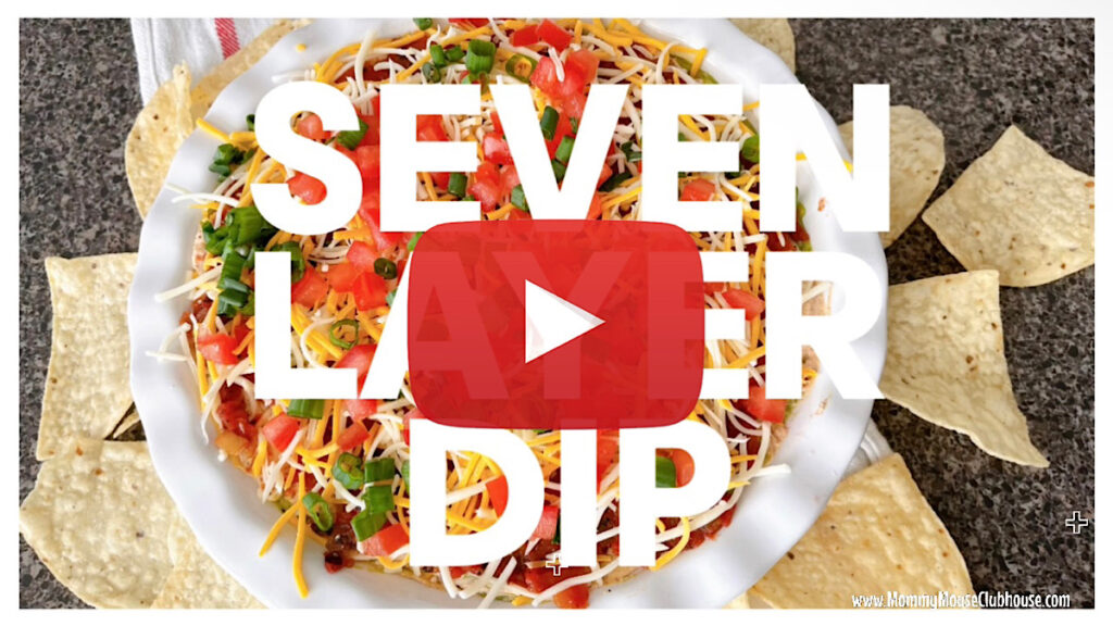 Seven Layer Dip text over a dish of Mexican bean dip.