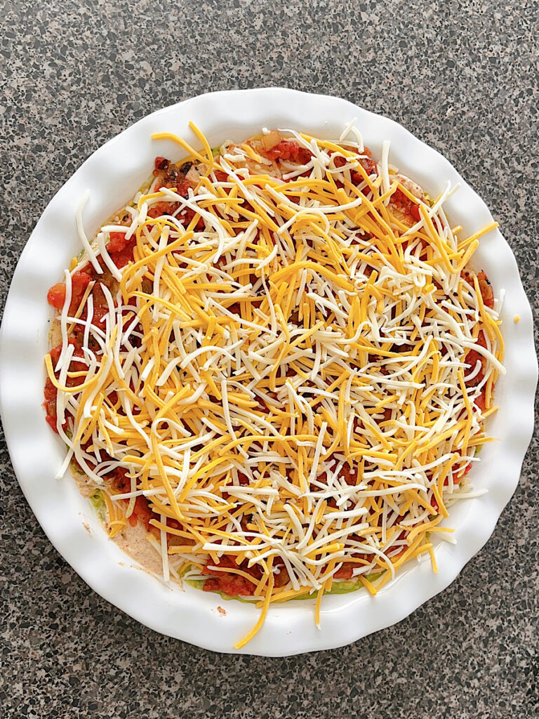 Cheese on top of the salsa layer in seven layer dip.