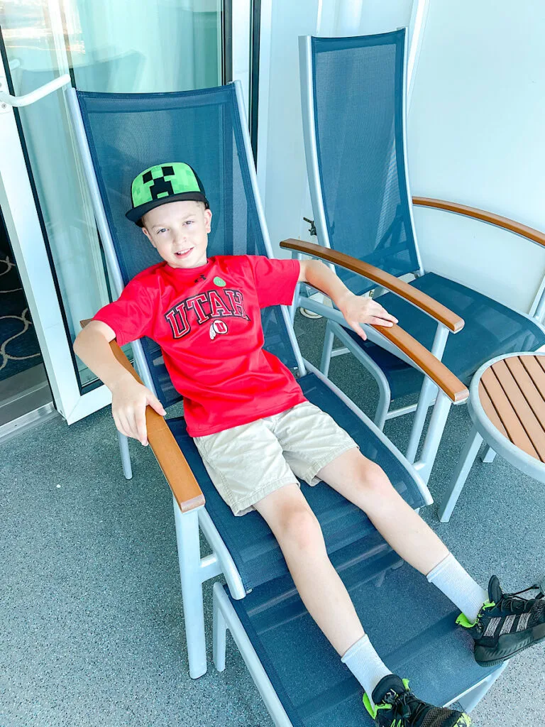 A child sitting on the balcony of Harmony of the Seas stateroom 14156.
