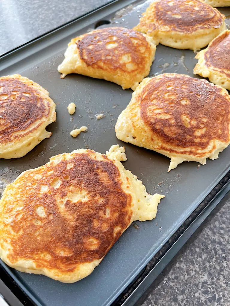 Sour cream pancakes on a hot griddle.