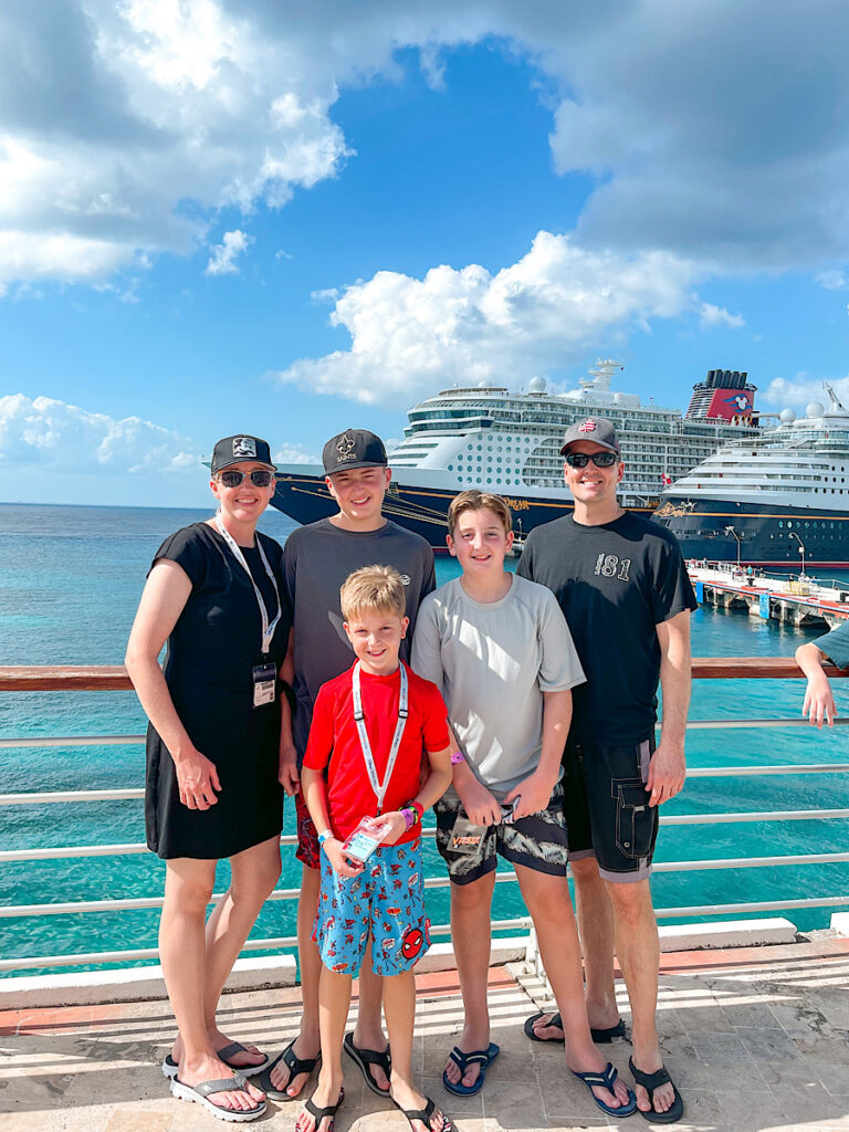 A family in front of the Disney Dream in the port of Cozumel.