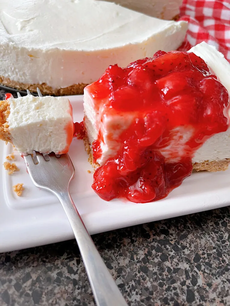 A slice of Philadelphia No Bake Cheesecake with strawberry sauce.