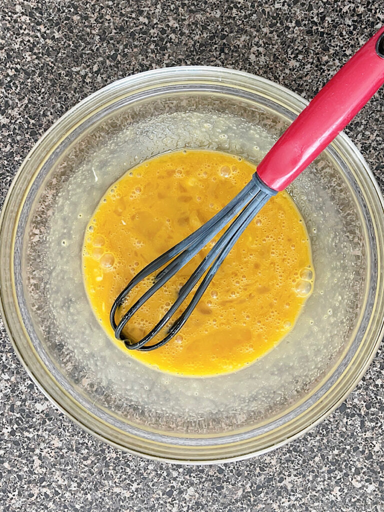 A bowl of wet ingredients to make sour cream pancakes.