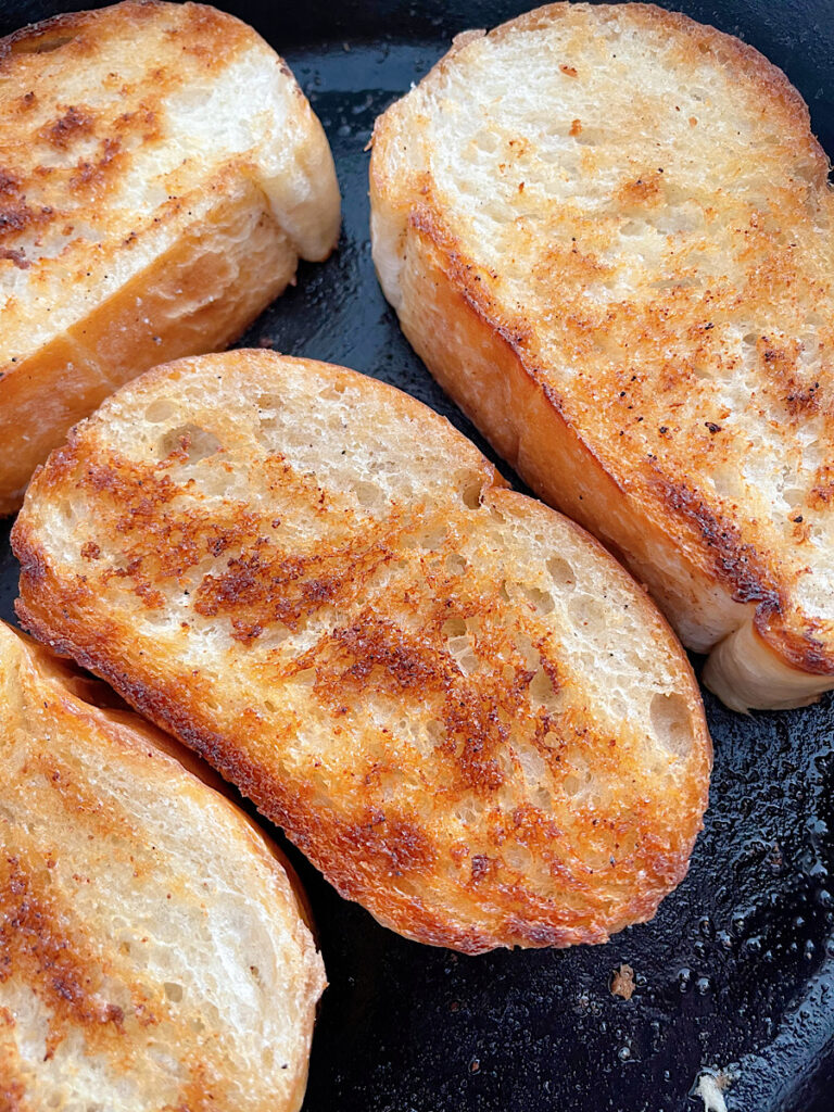 Raising Cane's bread toasting in a cast iron skillet.