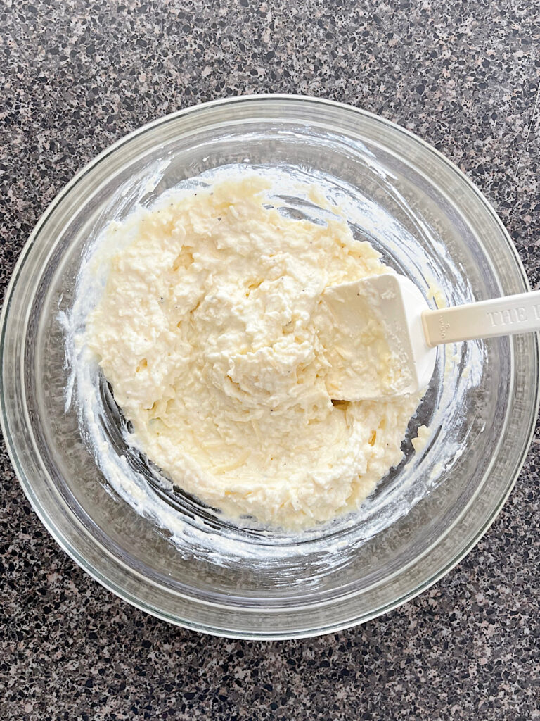 A bowl of mixed cheese including ricotta, mozzarella, parmesan, and romano.