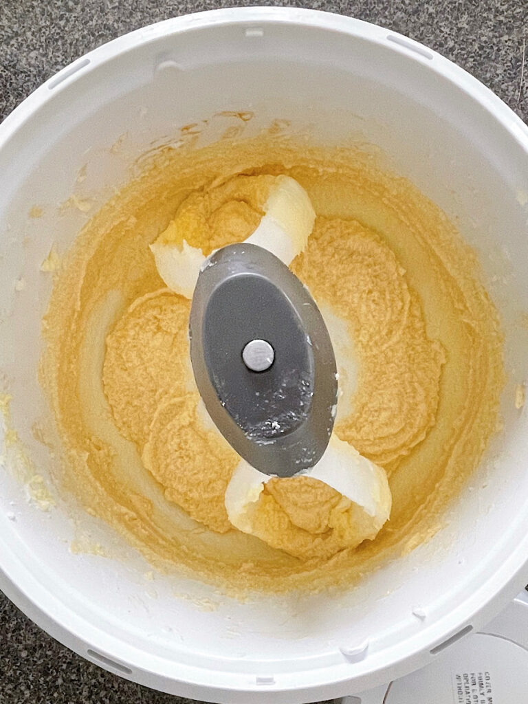 Wet ingredients for sugar cookies in the bowl of a stand mixer.