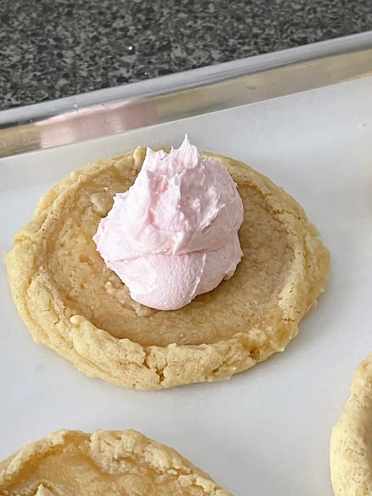 Pink frosting on a chilled sugar cookie.