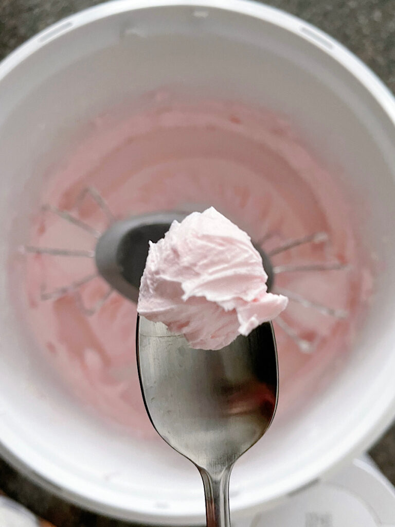 A spoonful of pink buttercream frosting.
