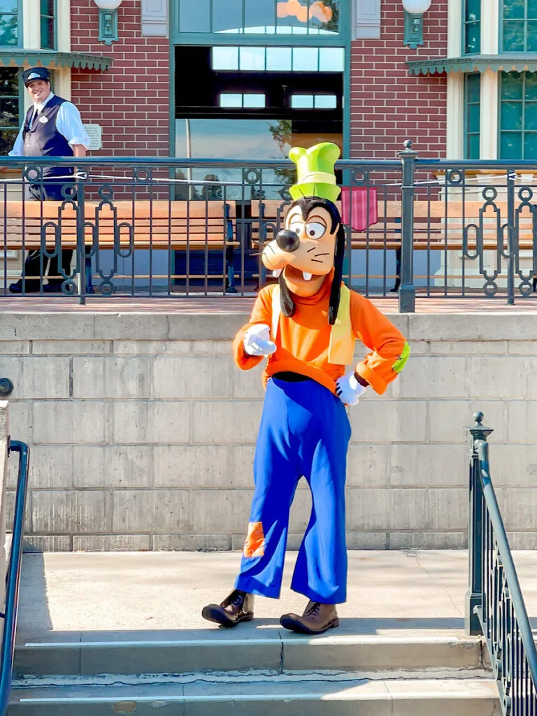 Goofy on the steps of the Disneyland Railroad Main Street Station.
