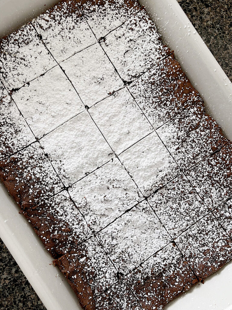 A pan of brownies with powdered sugar.