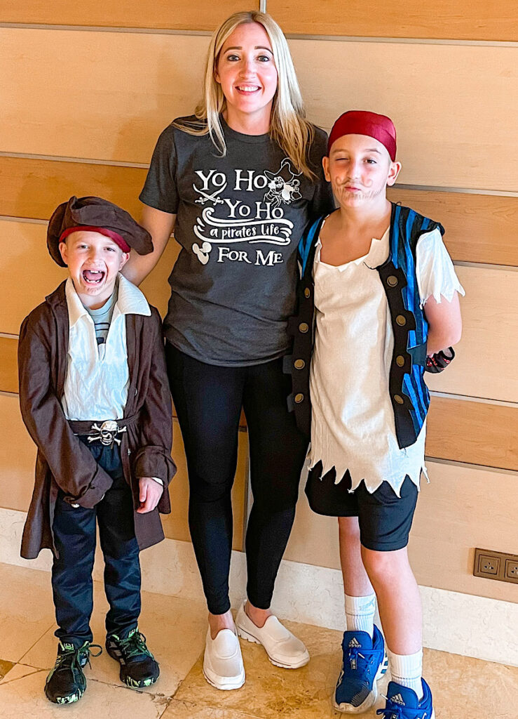 A mom and two kids dressed up as pirates for pirate night on a Disney Cruise.