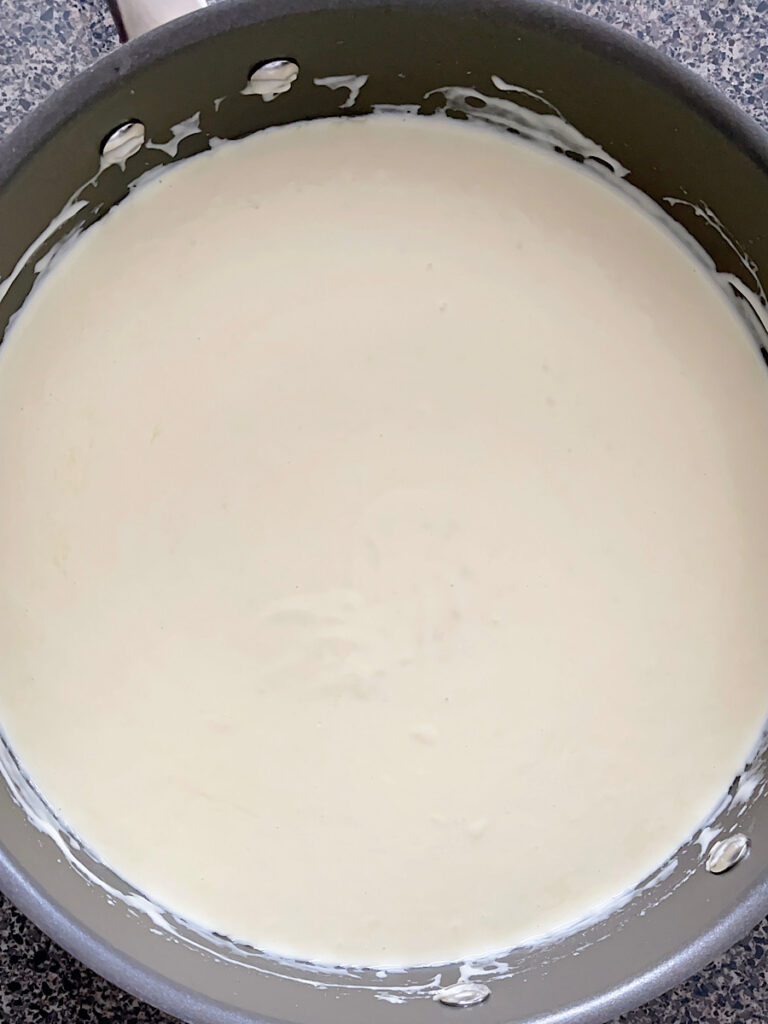 Heavy cream and milk in a sauce pan to make Alfredo sauce.