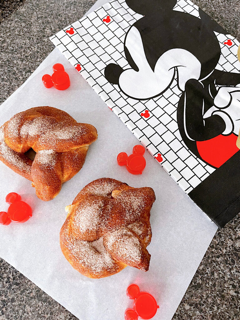 A soft pretzel covered in cinnamon sugar and filled with cream cheese on a wire rack.