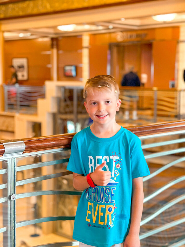 A child on the Disney Magic with a Best Cruise Ever shirt.