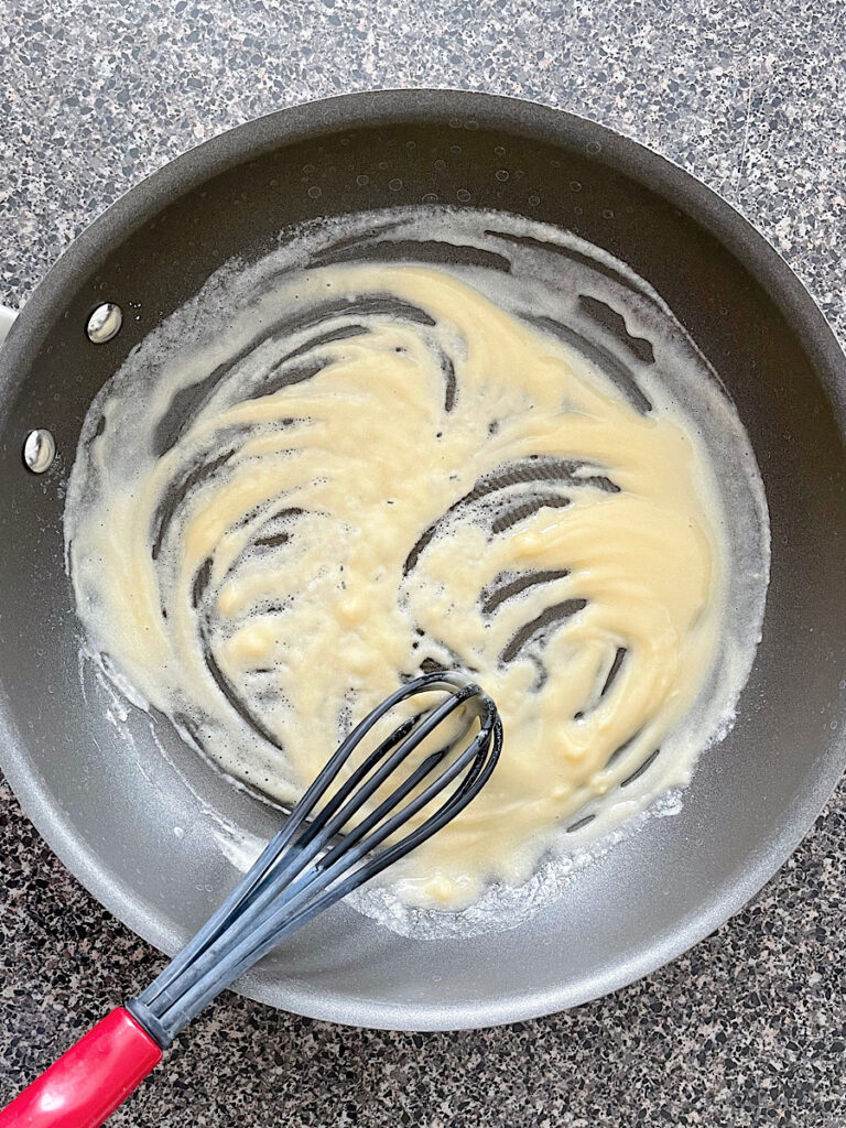 Butter and flour in a skillet to make a roux for sour cream enchilada sauce.