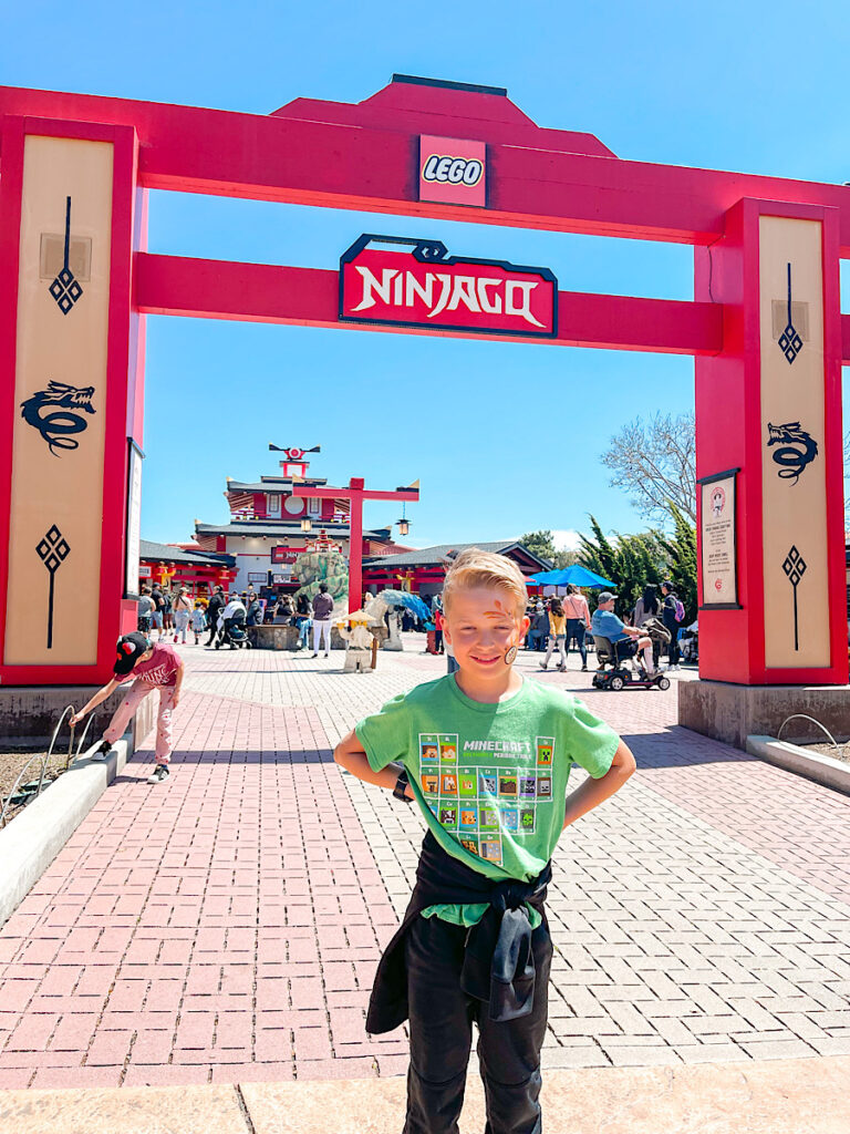 A child in front of Ninjago the ride at Legoland California.