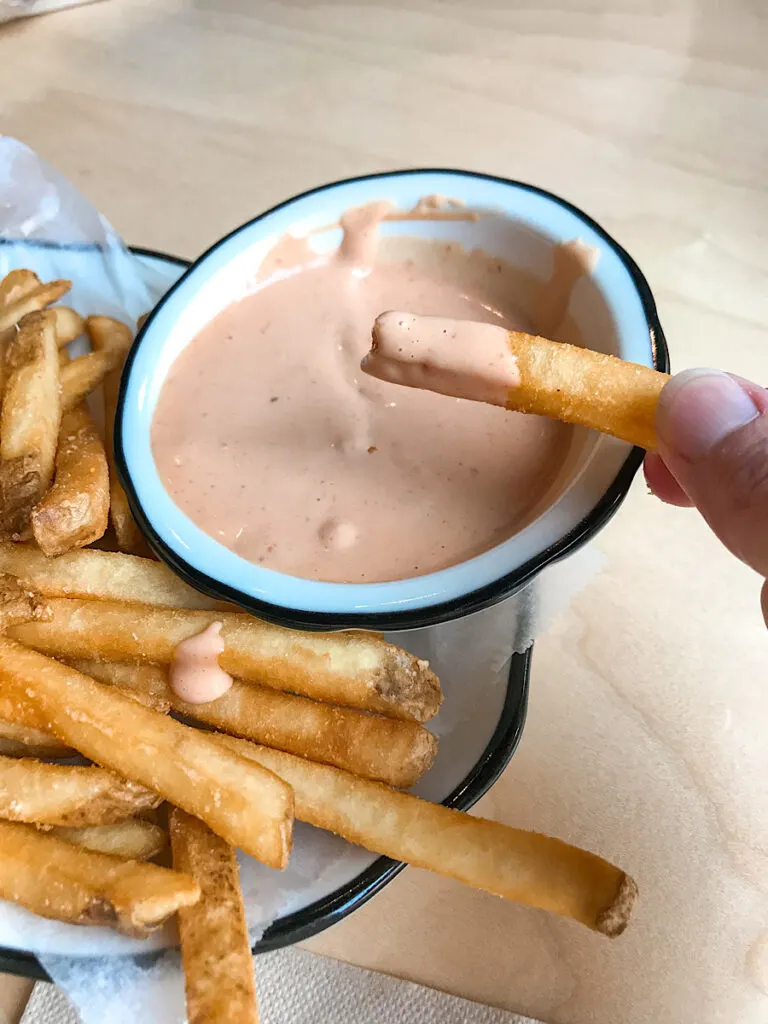Fries dipped in fry sauce at Black Tap Anaheim.