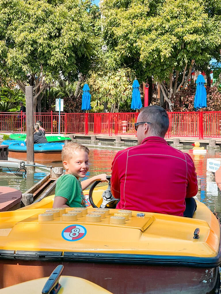 A child and his dad in a boat ride at Legoland California.