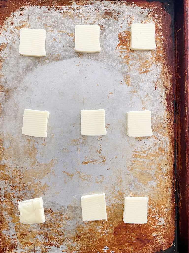 Slices of butter on a baking sheet.