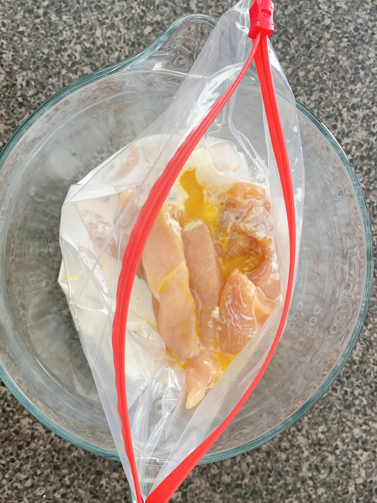 Chicken strips in a ziplock bag with buttermilk and egg.