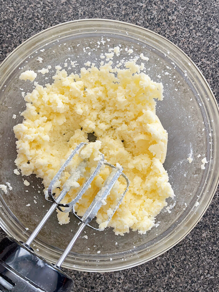 Butter and sugar in a mixing bowl with an electric mixer.