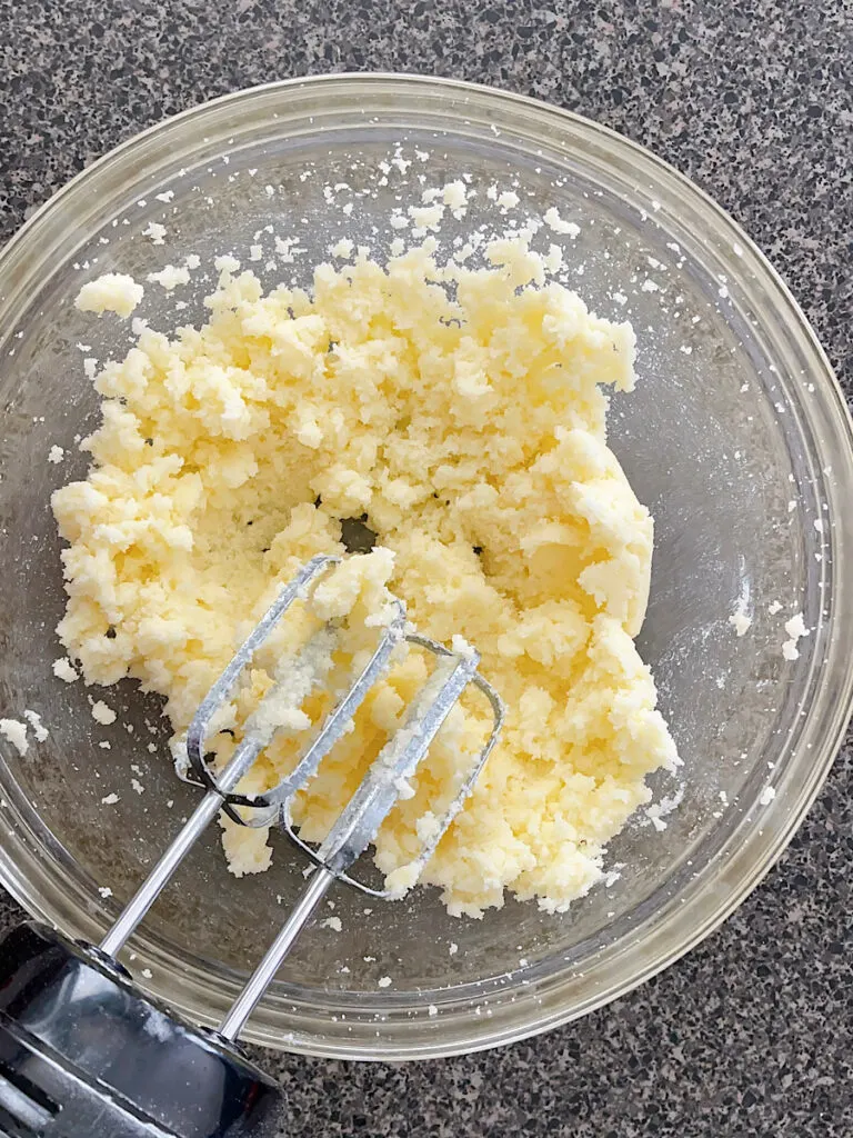 Butter and sugar in a mixing bowl with an electric mixer.