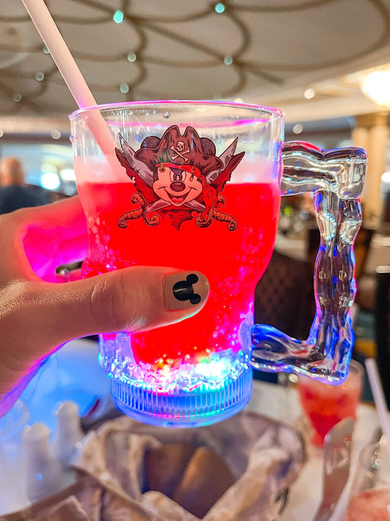 A red drink in a Mickey Mouse pirate cup.
