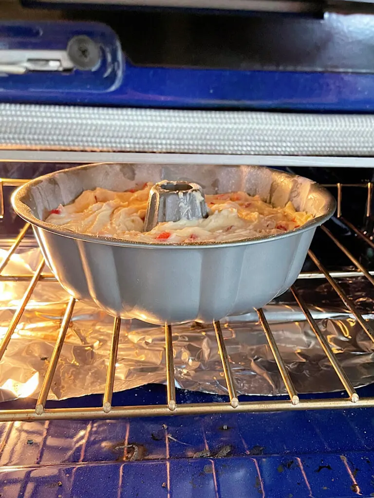 A strawberry bundt cake baking in an oven.