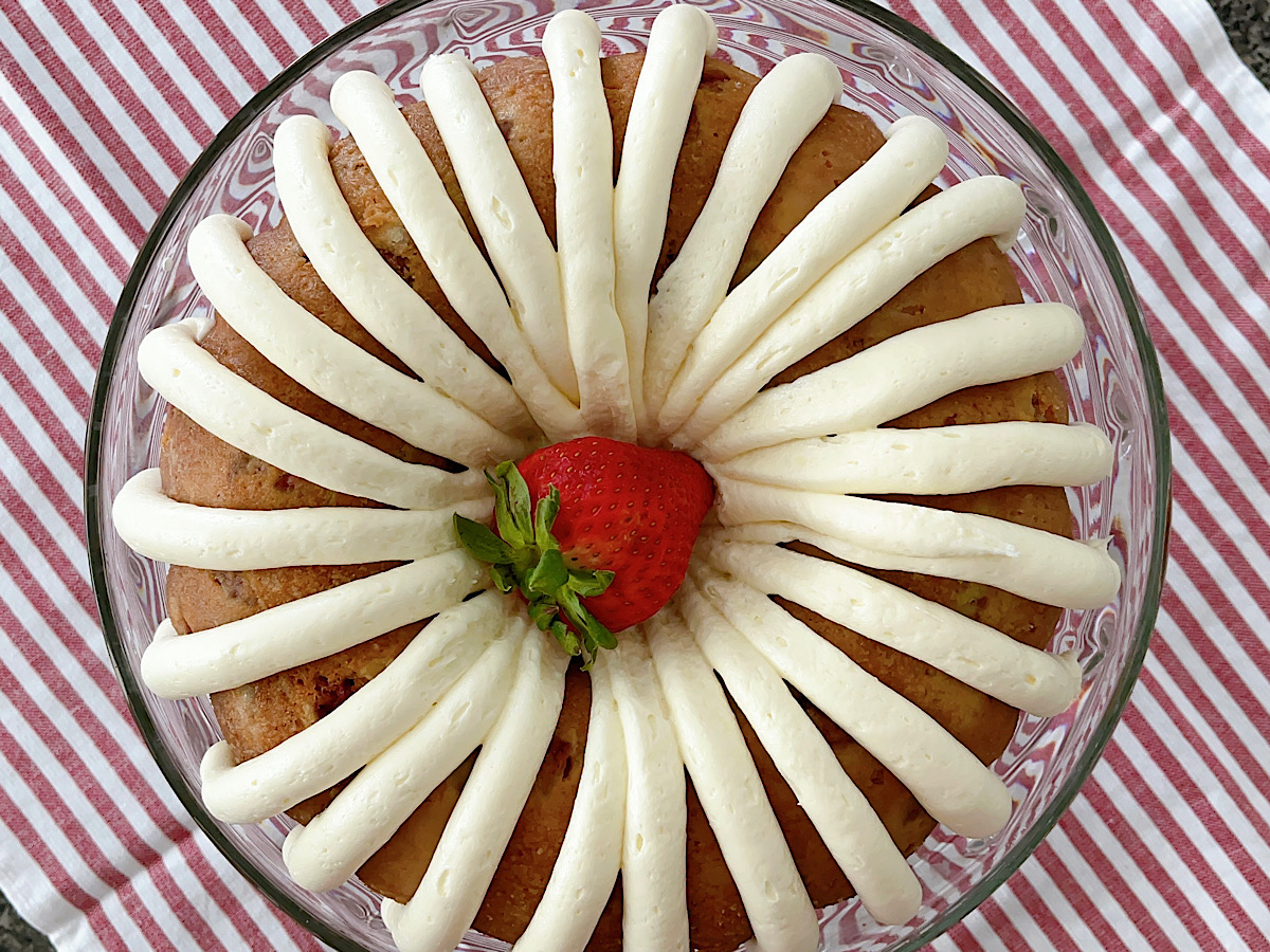 A strawberry bunt cake with white chocolate frosting.