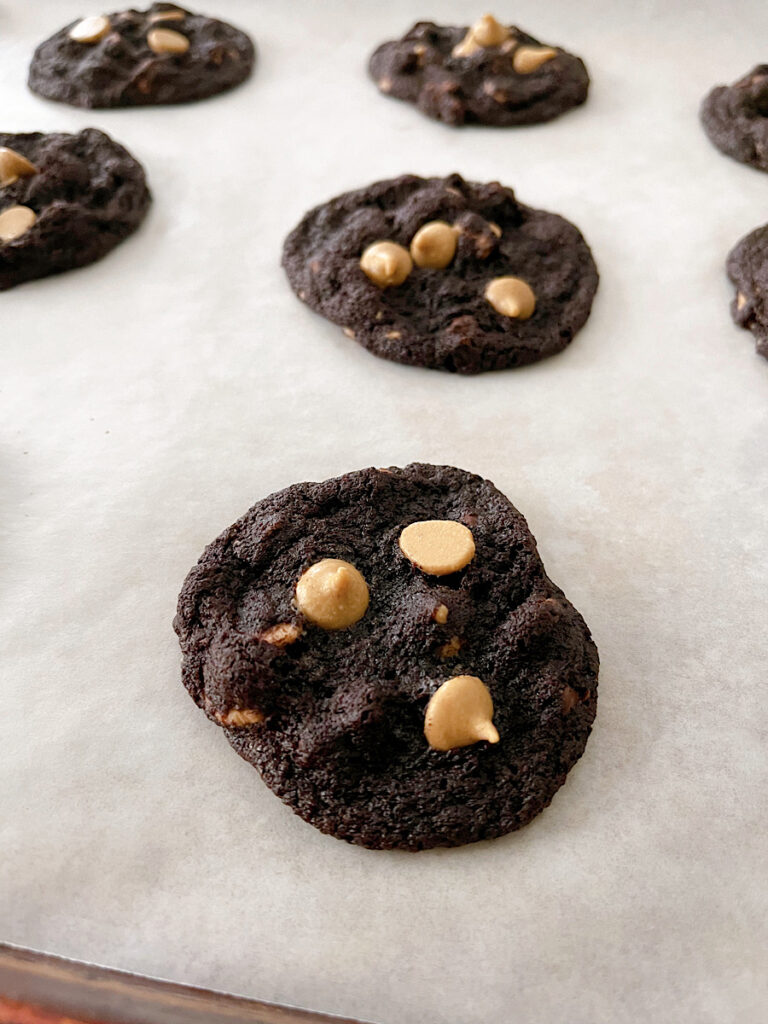 Reese's Chocolate peanut butter chip cookies on parchment paper.