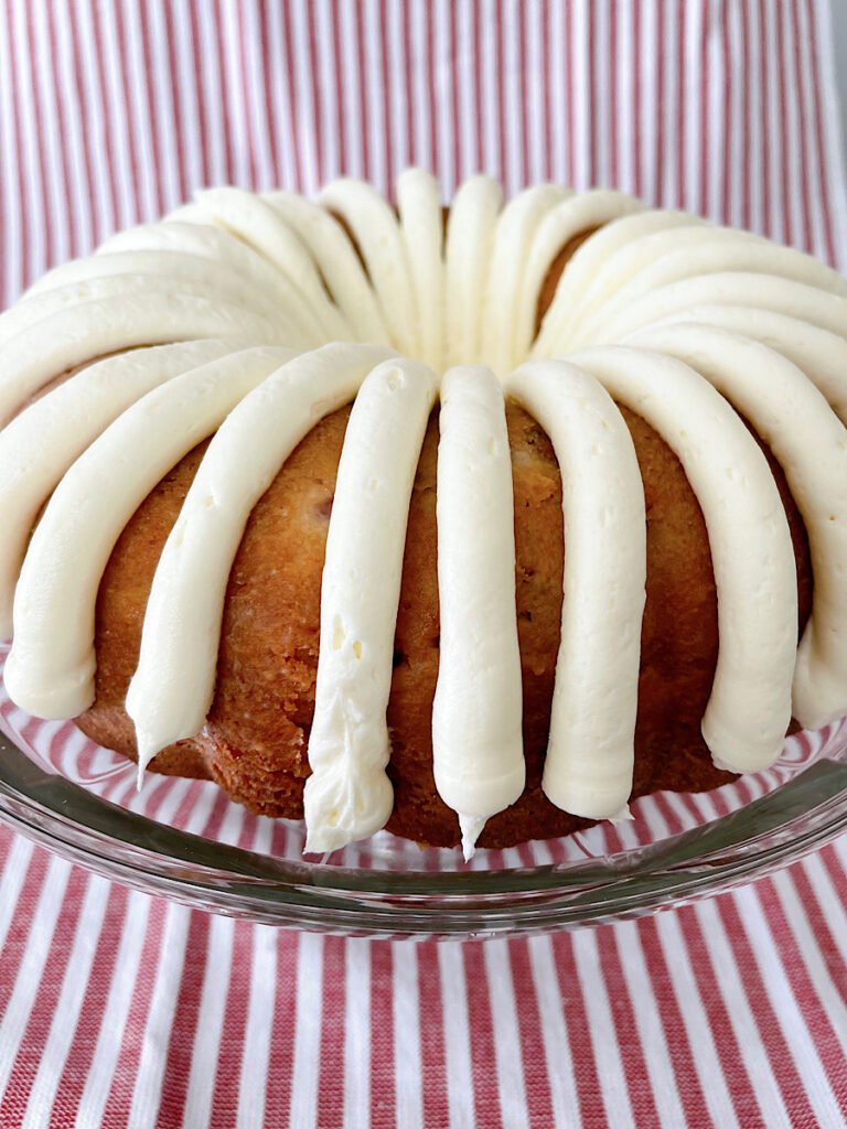 A strawberry bunt cake with white chocolate frosting.