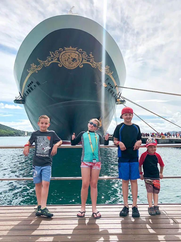 Four kids standing in front of the Disney Fantasy cruise ship.