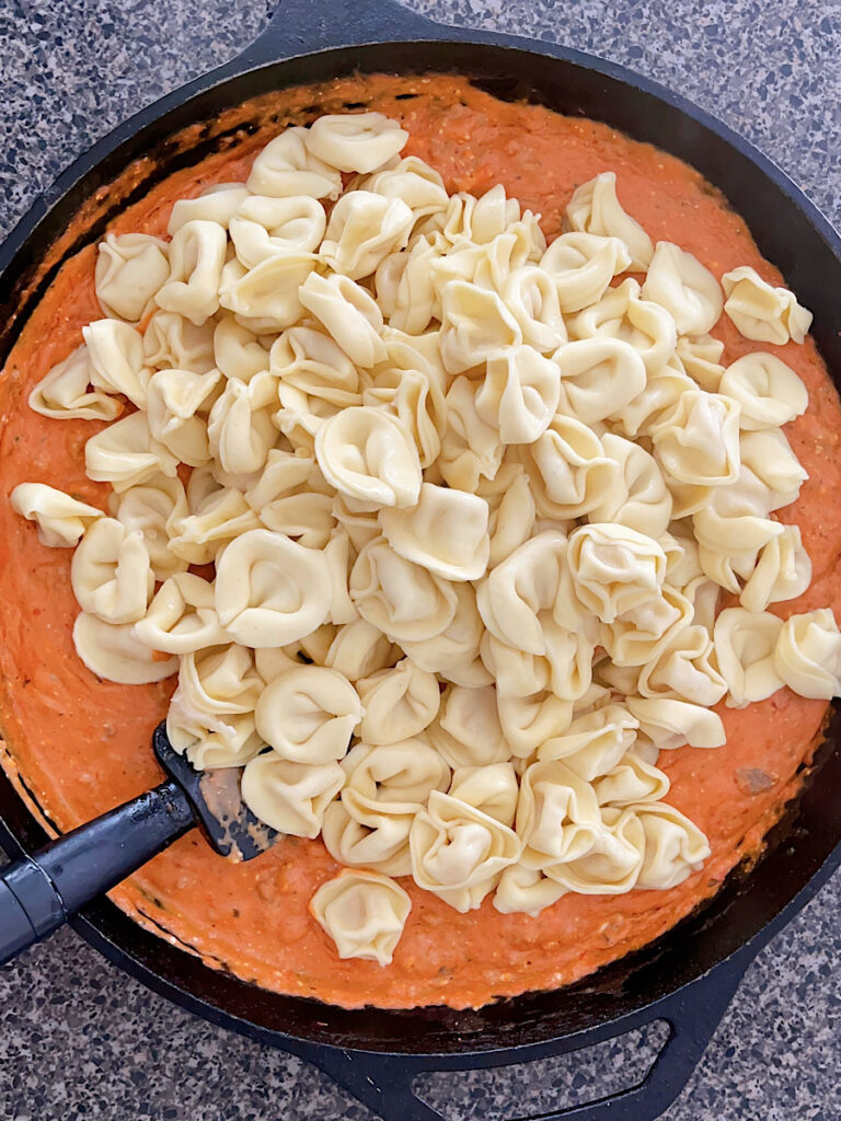 Tortellini in a pan of sauce to make TikTok tortellini.