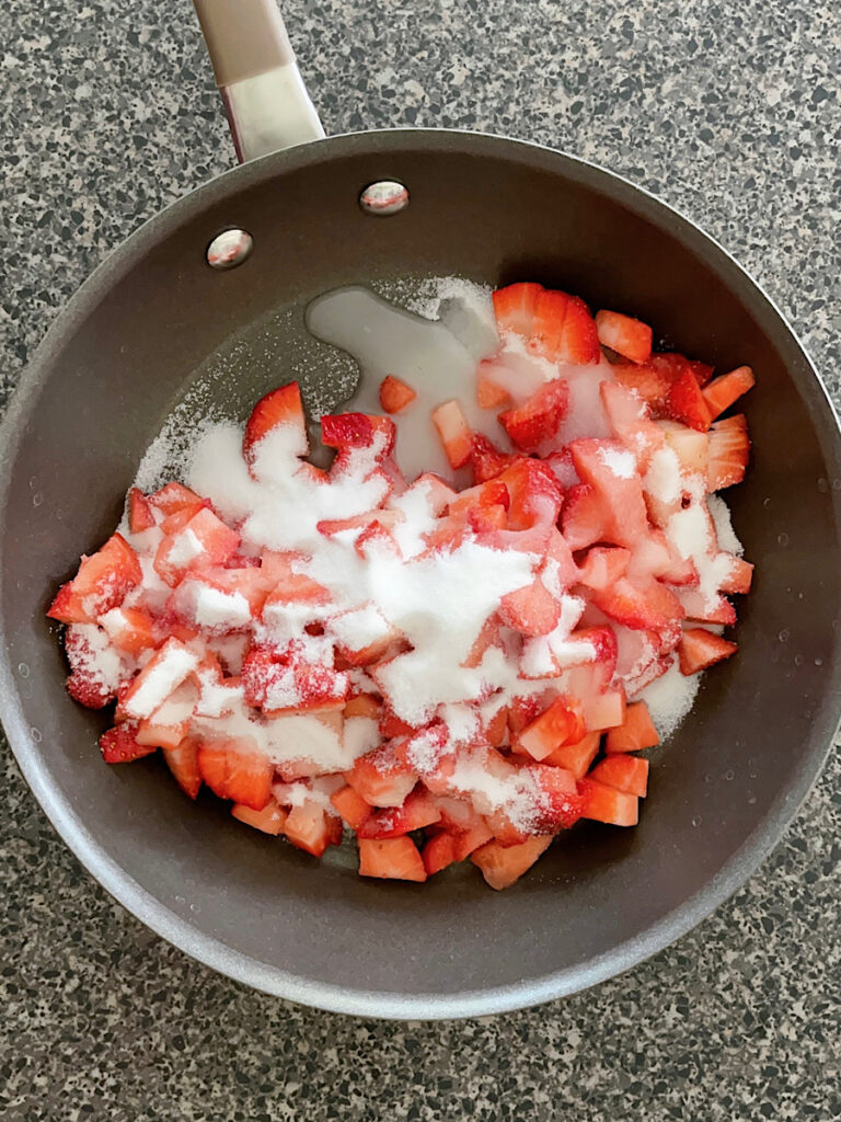 Strawberries, sugar, and lemon juice in a saucepan.