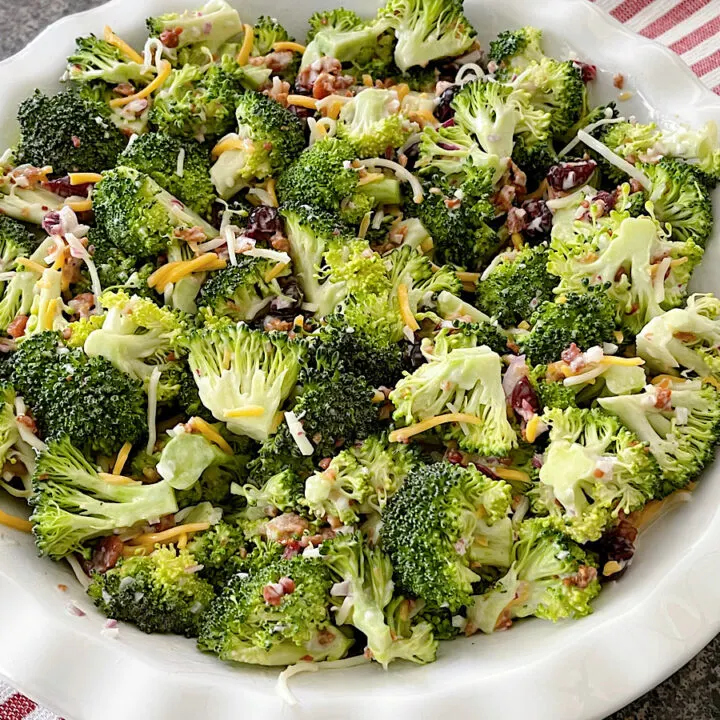 Broccoli salad with craisins in a white dish.