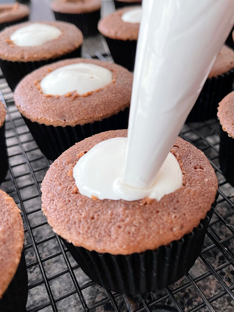 Marshmallow cream piped into the center of chocolate cupcakes.