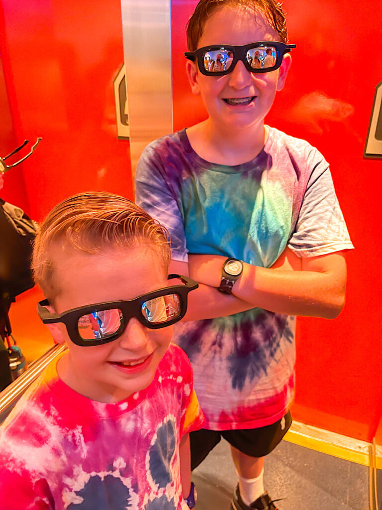 Two kids in 3D glasses about to ride Star Tours at Hollywood Studios.