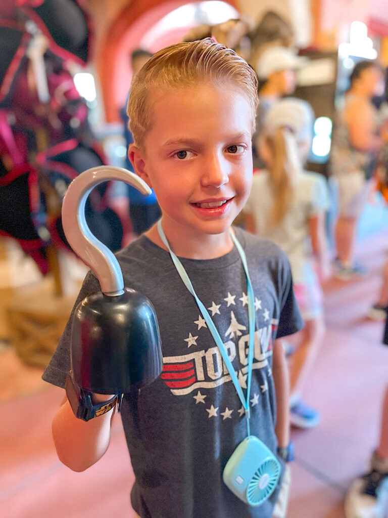 A child in the Pirate's of the Caribbean gift shop with a hook hand.