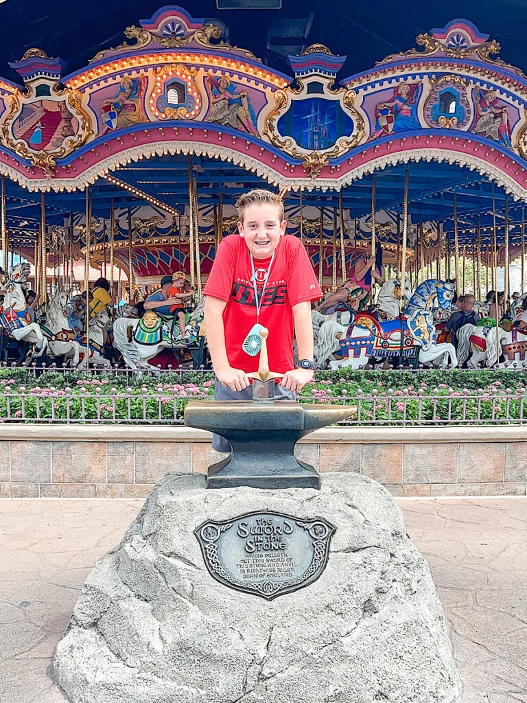 A child trying to pull the sword from the stone at Disney World.