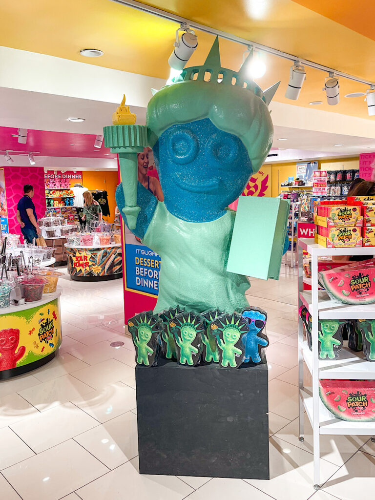 A sour patch kid dressed like the Statue of Liberty at Macy's in New York.