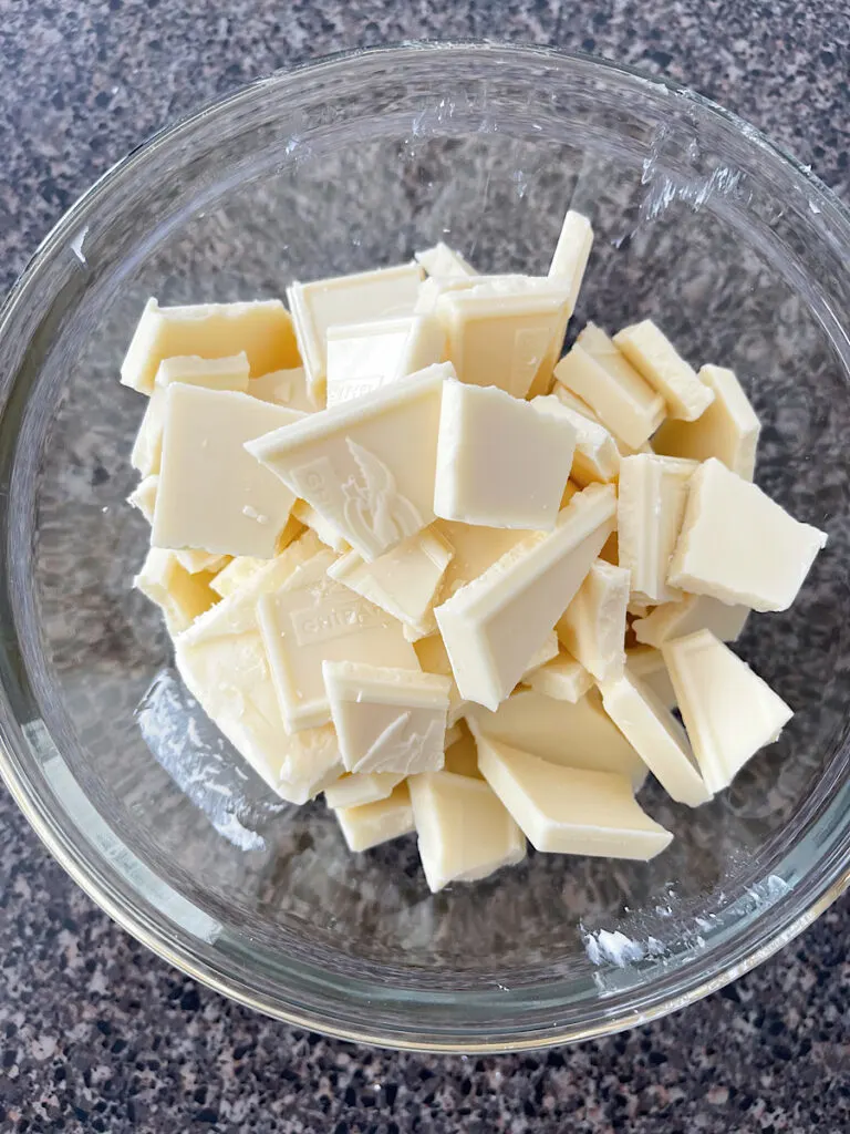 A bowl of white chocolate chunks and butter.