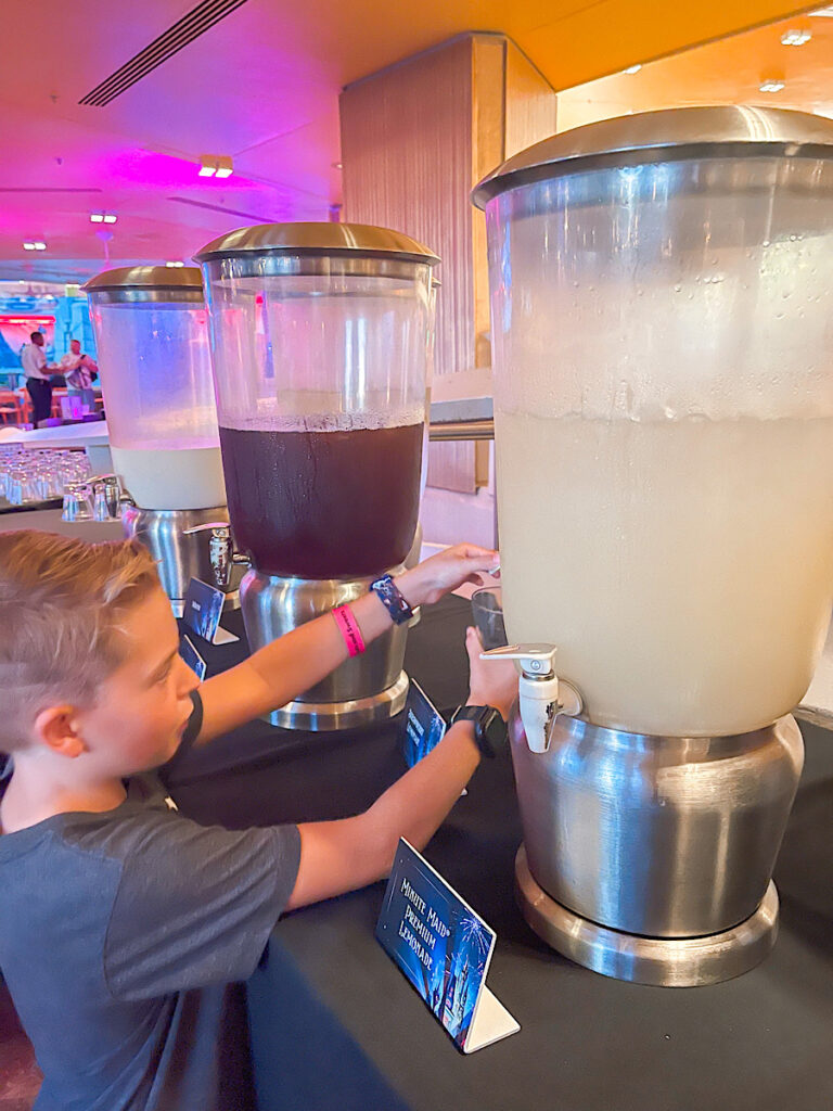 A child getting a drink from a Disney dessert party.
