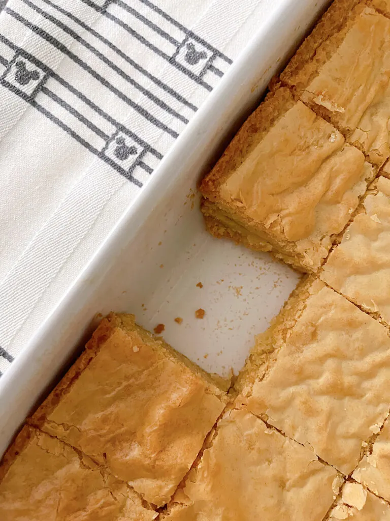 A pan of white chocolate brownies with one removed.