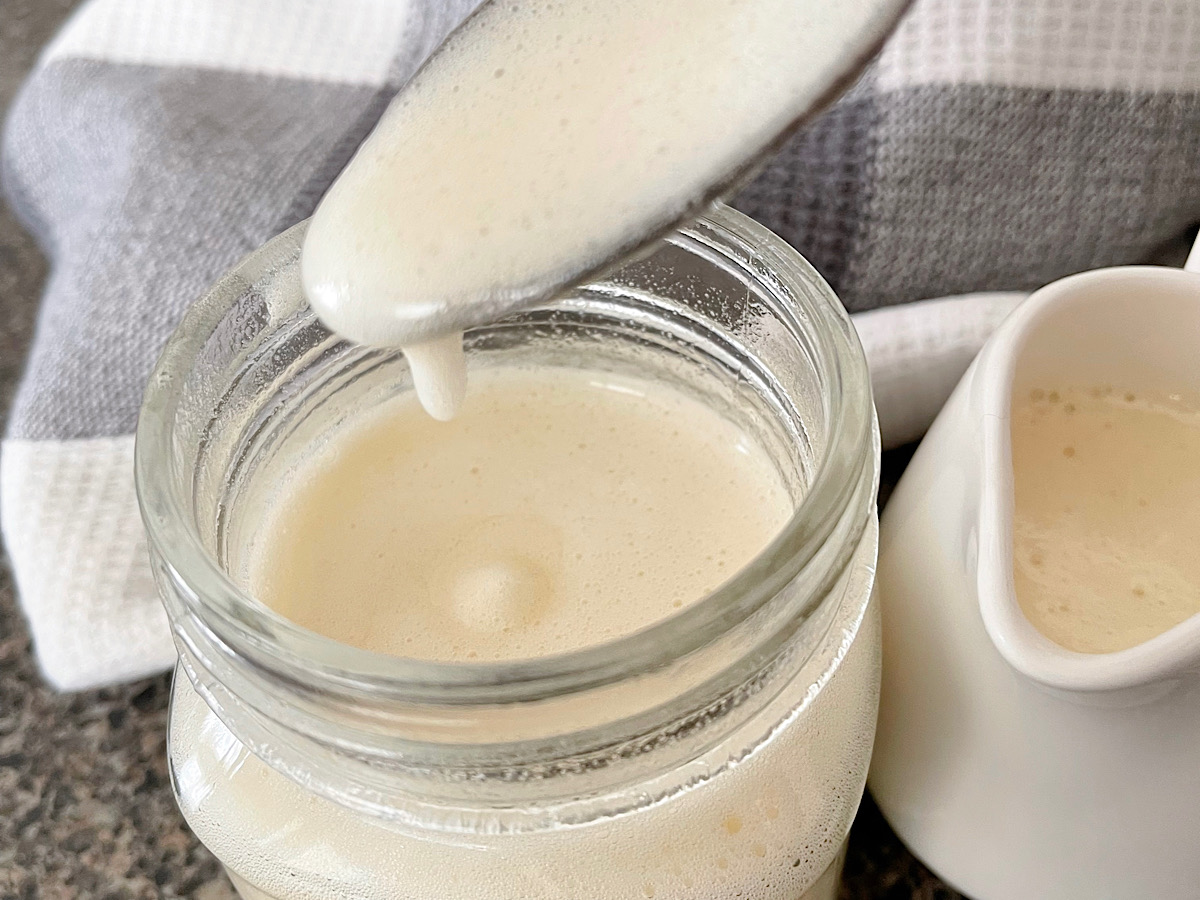 A jar spoon and jar full of buttermilk syrup.