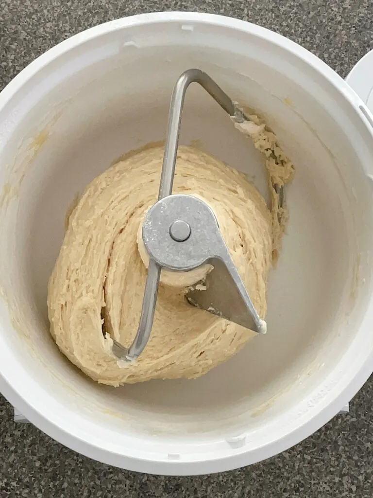 Dough in a stand mixer with a dough hook attachment.