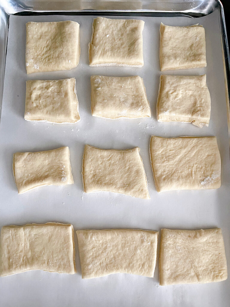 Unbaked rolls on a baking sheet.