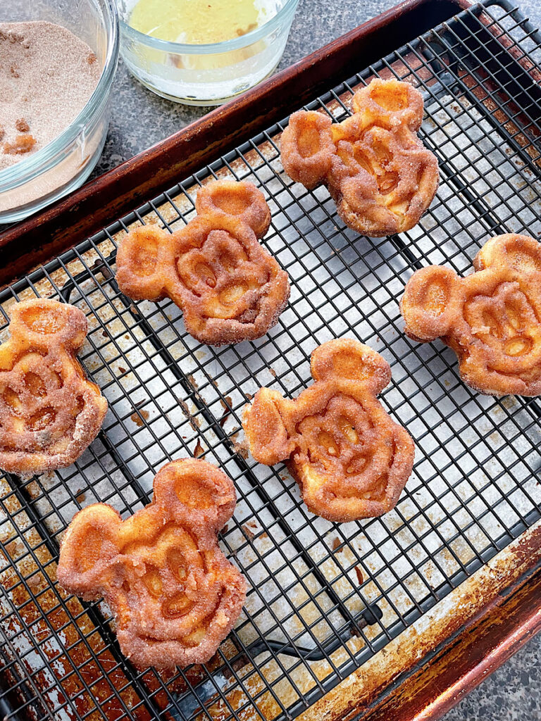 Churro Mickey waffles on a wire rack.