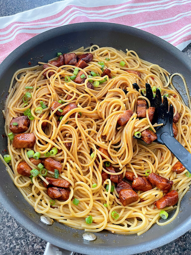 Spicy Thai noodles with chicken in a large skillet.