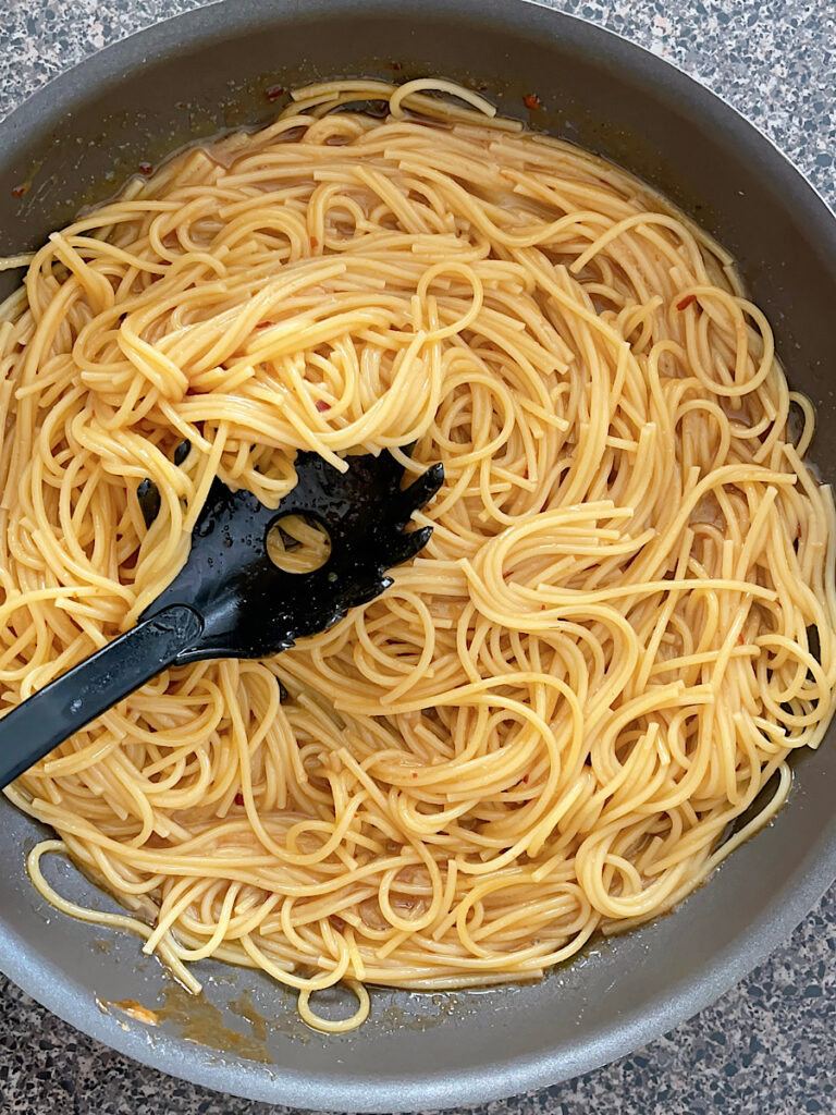 Spicy Thai noodles with chicken in a large skillet.