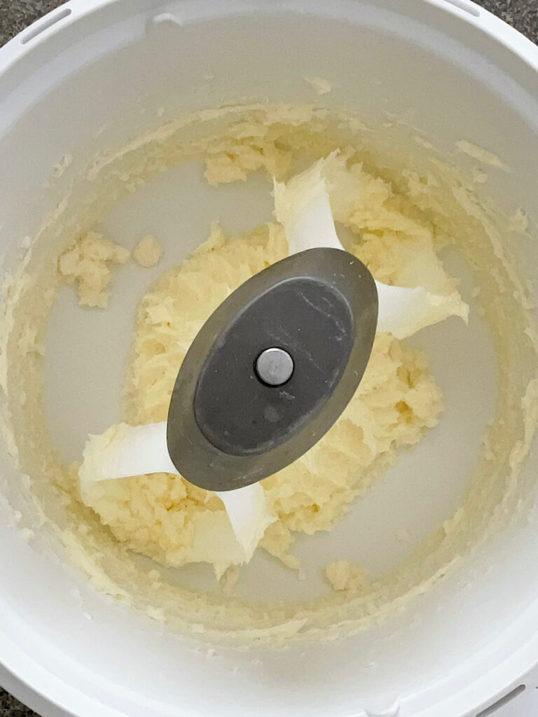 Butter and sugar mixed in a mixing bowl.